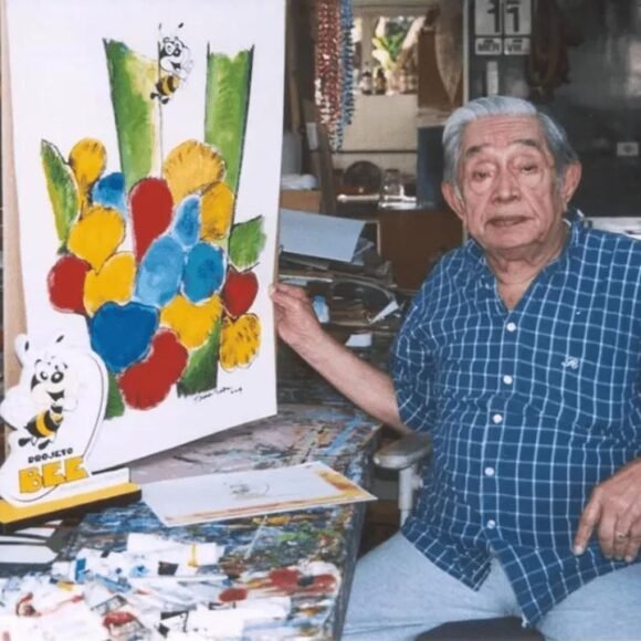 Aldemir Martins em seu ateliê com uma de suas obras coloridas