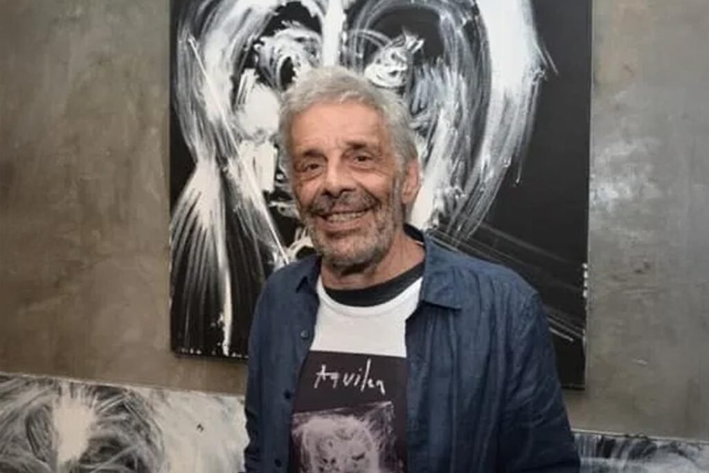 José Roberto Aguilar em frente a uma de suas obras expressionistas em preto e branco