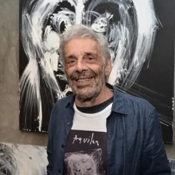 José Roberto Aguilar em frente a uma de suas obras expressionistas em preto e branco